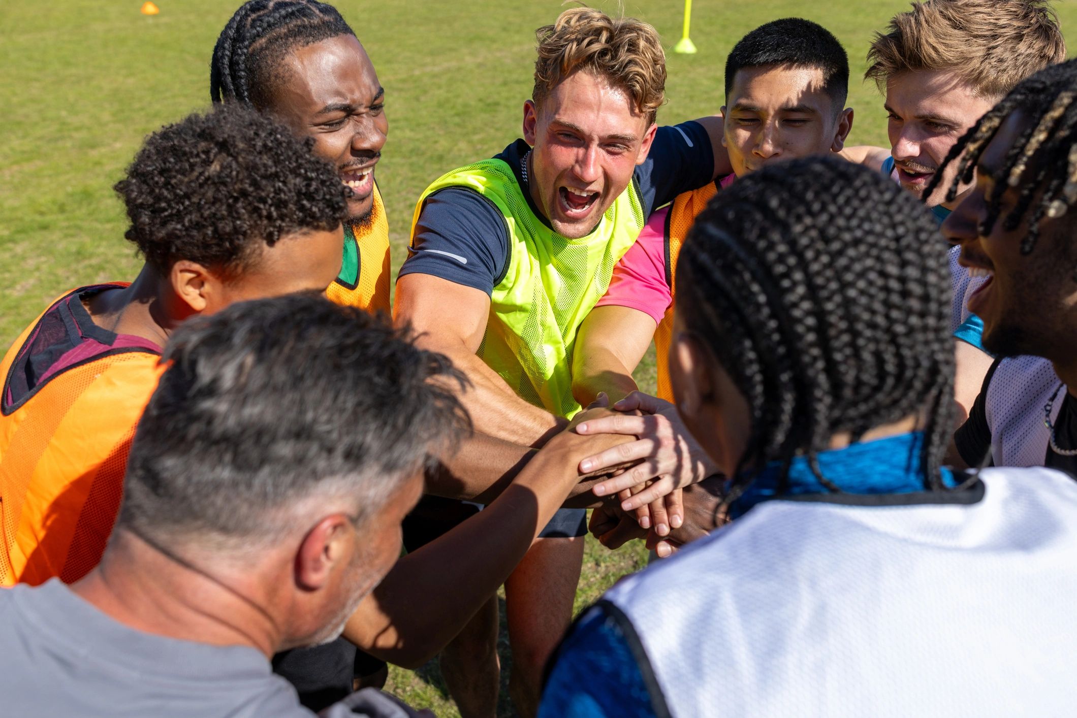 Football team with hands together in a huddle
